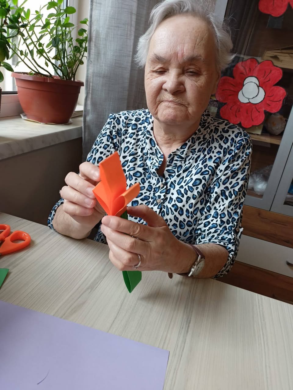 Pani podczas warsztatów origami — papierowy tulipan